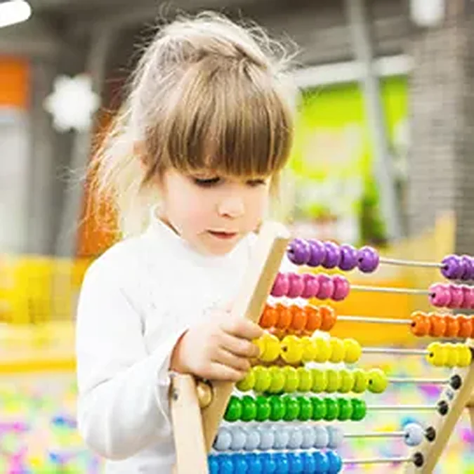 Girl playing with a wooden abacus
