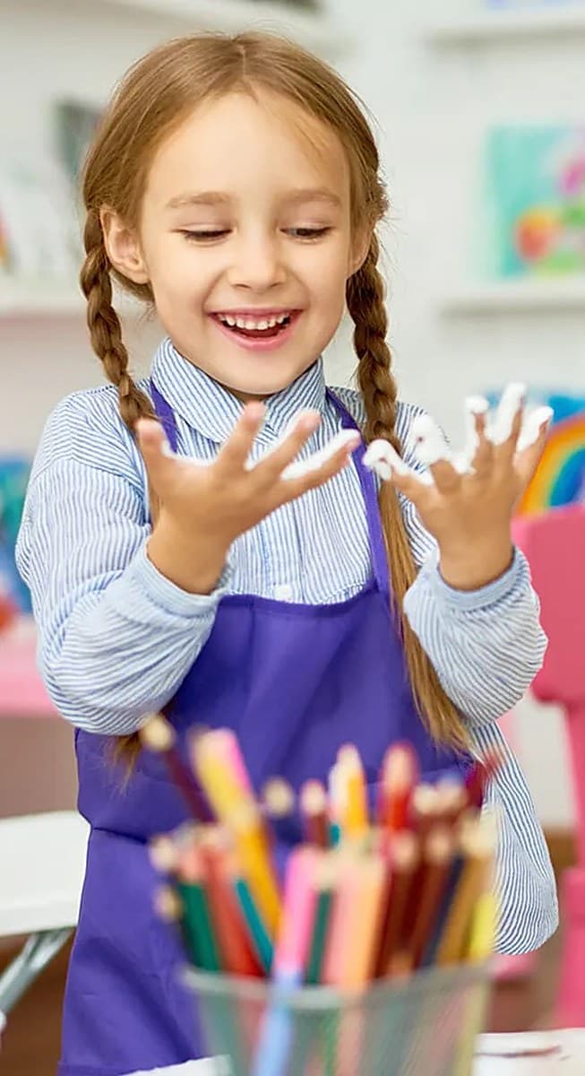 Child painting with bright colors in art class