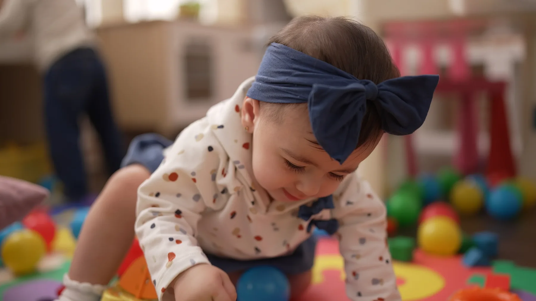 Toddler reaching for balls during active play